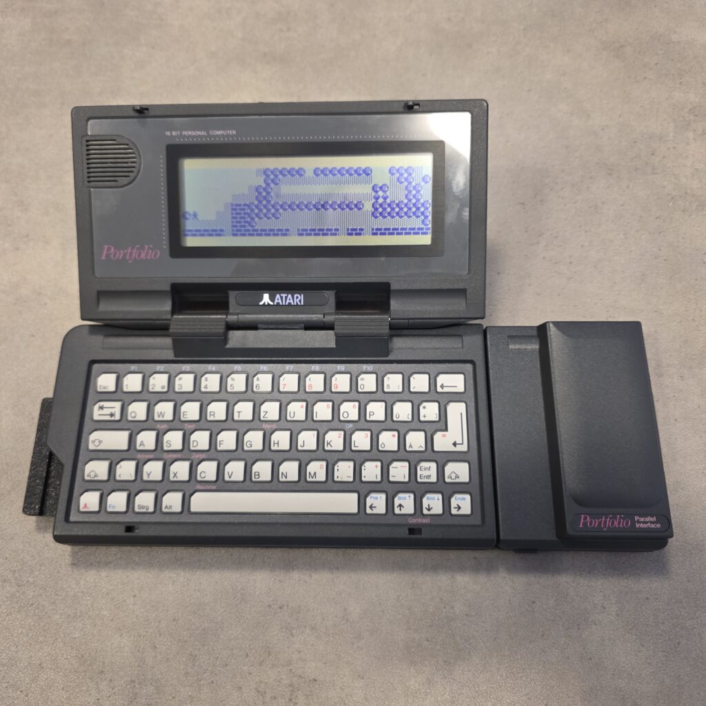 Atari Portfolio HPC-006 s připojeným paralelním portem HPC-101 (na obrazovce hra Folidash)